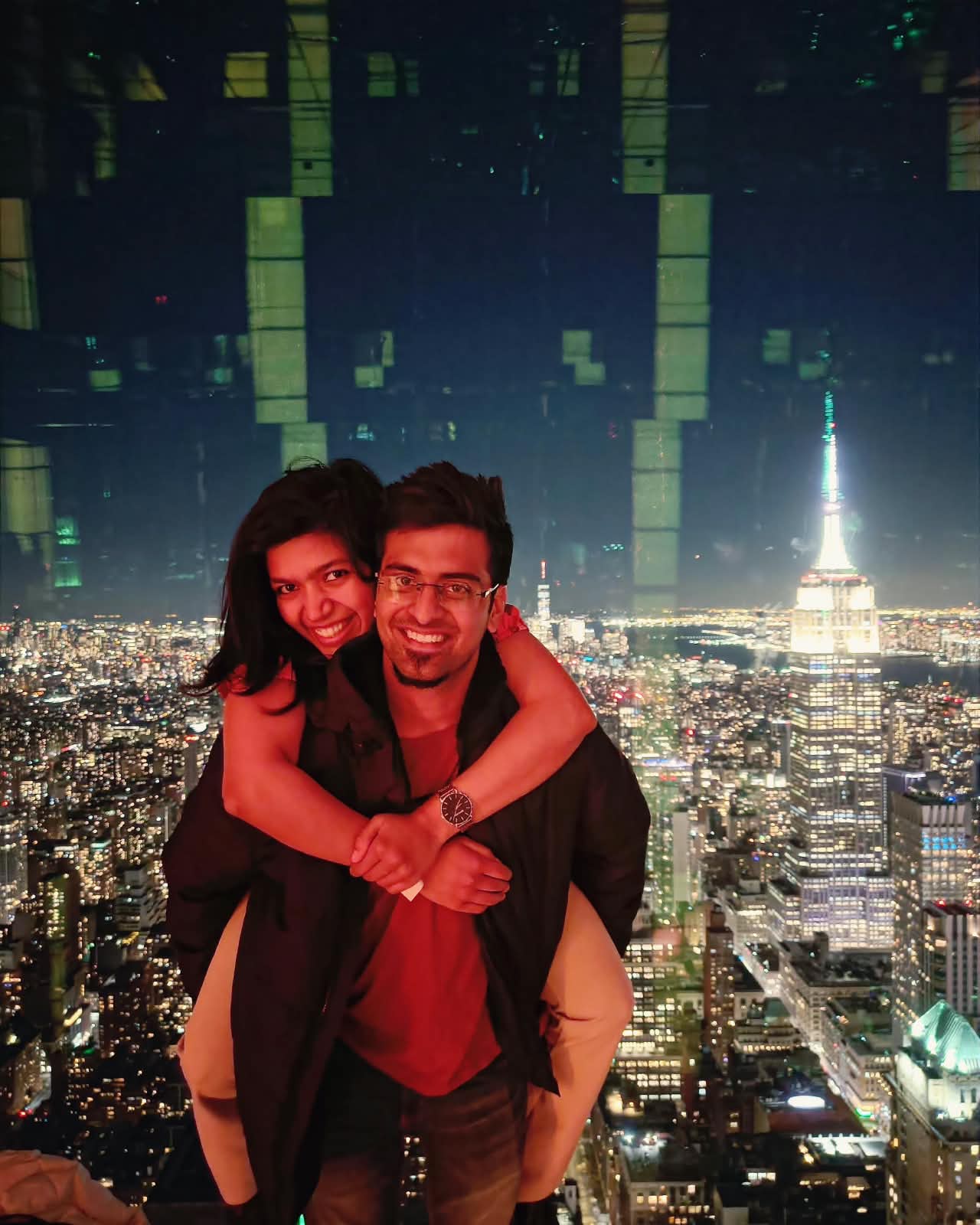 Deepthi and Adith Kiran above the New York City skyline at night