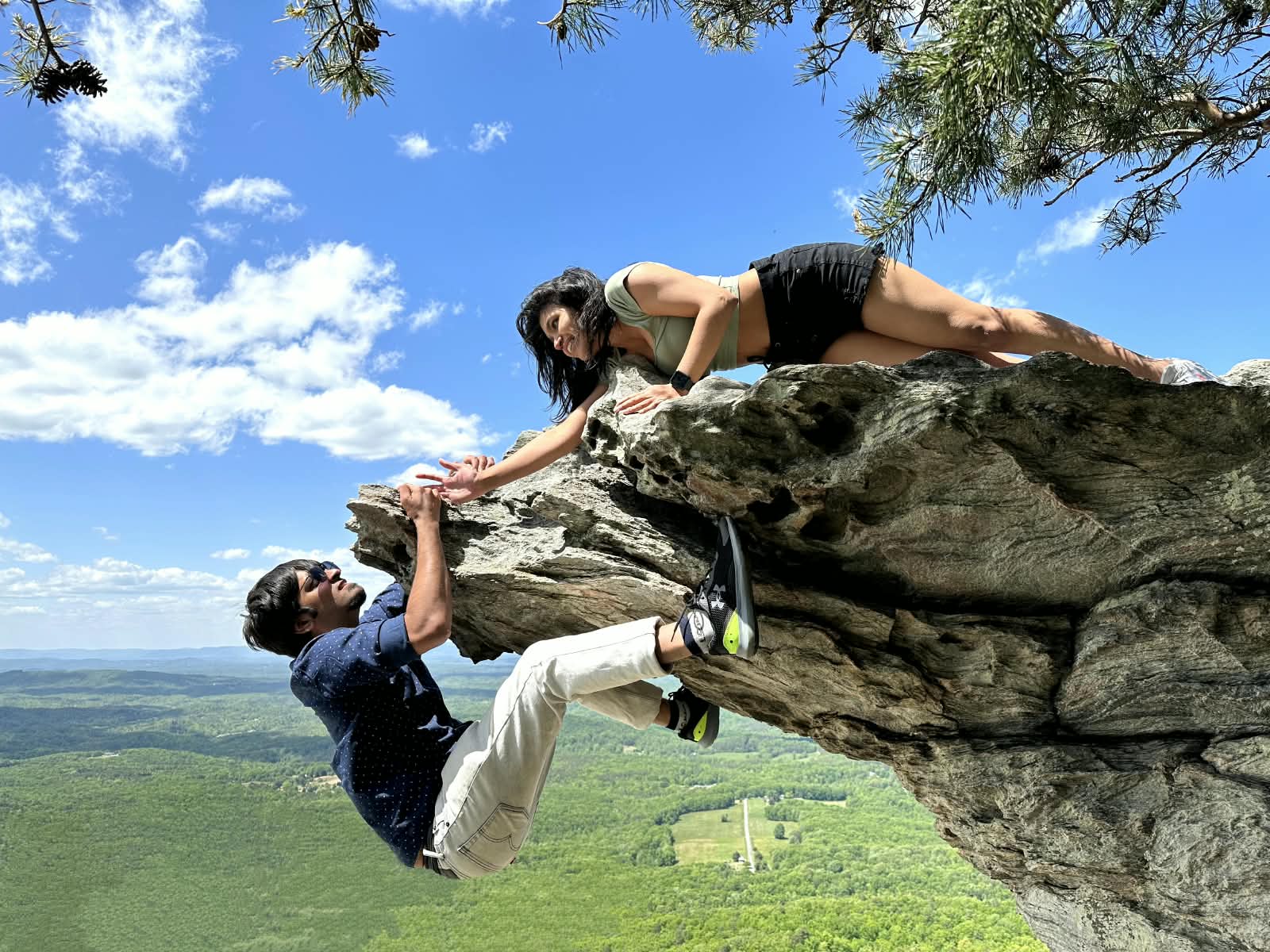 Deepthi and Adith Kiran playfully hanging off a cliff edge
